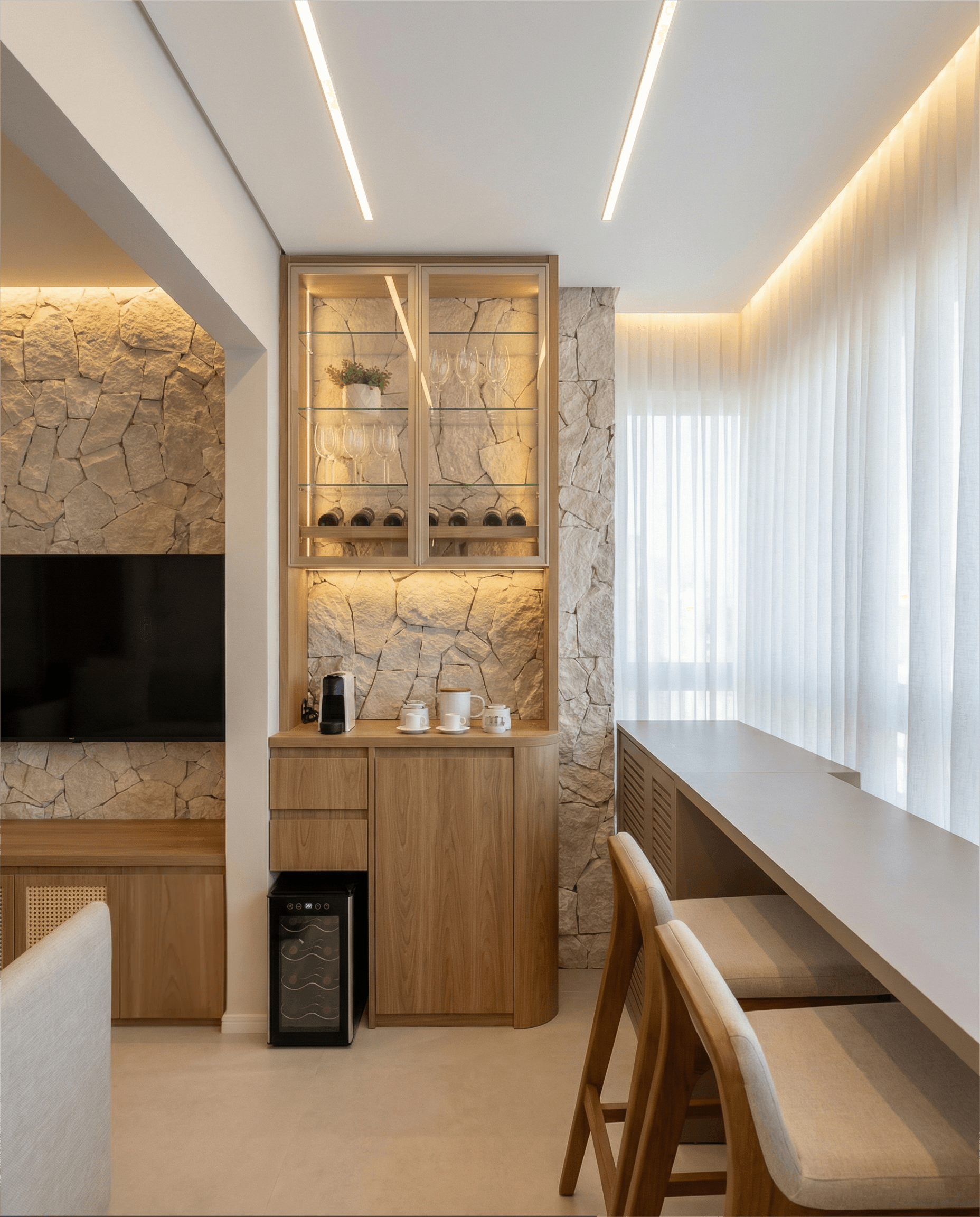 Sala, jantar e cozinha integrados com parede de pedra